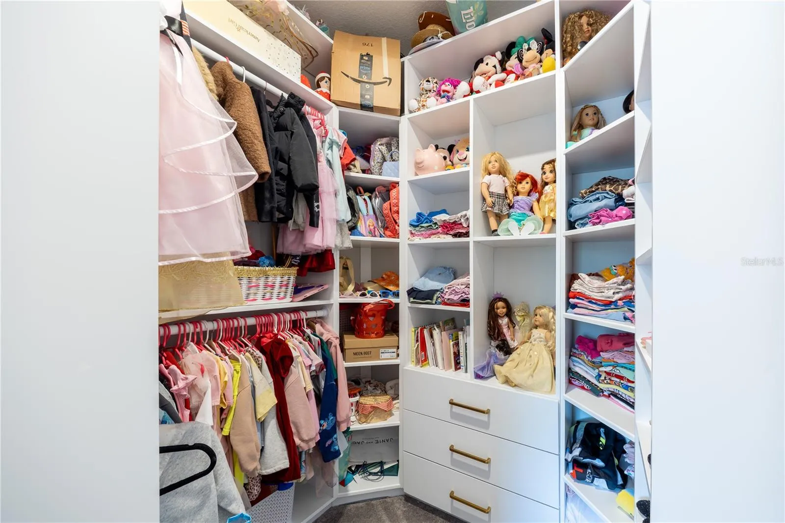 Custom walk-in closet with built-in shelving, drawers, and double hanging rods.