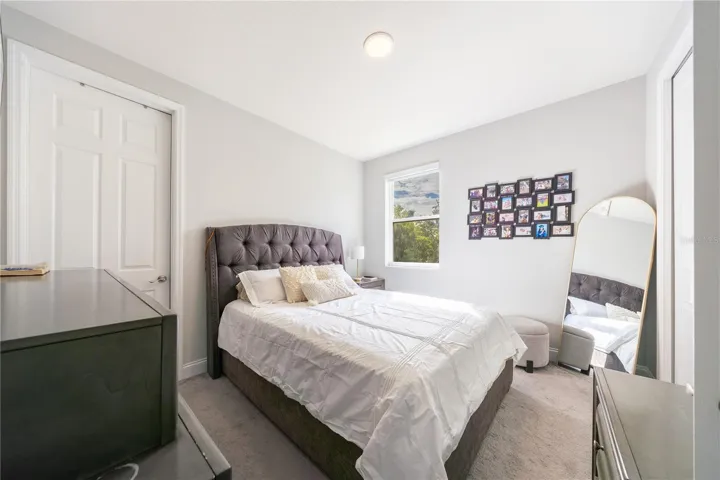 Inviting bedroom with soft carpeting, neutral tones, and a double-door closet.
