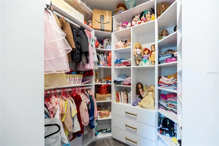 Custom walk-in closet with built-in shelving, drawers, and double hanging rods.