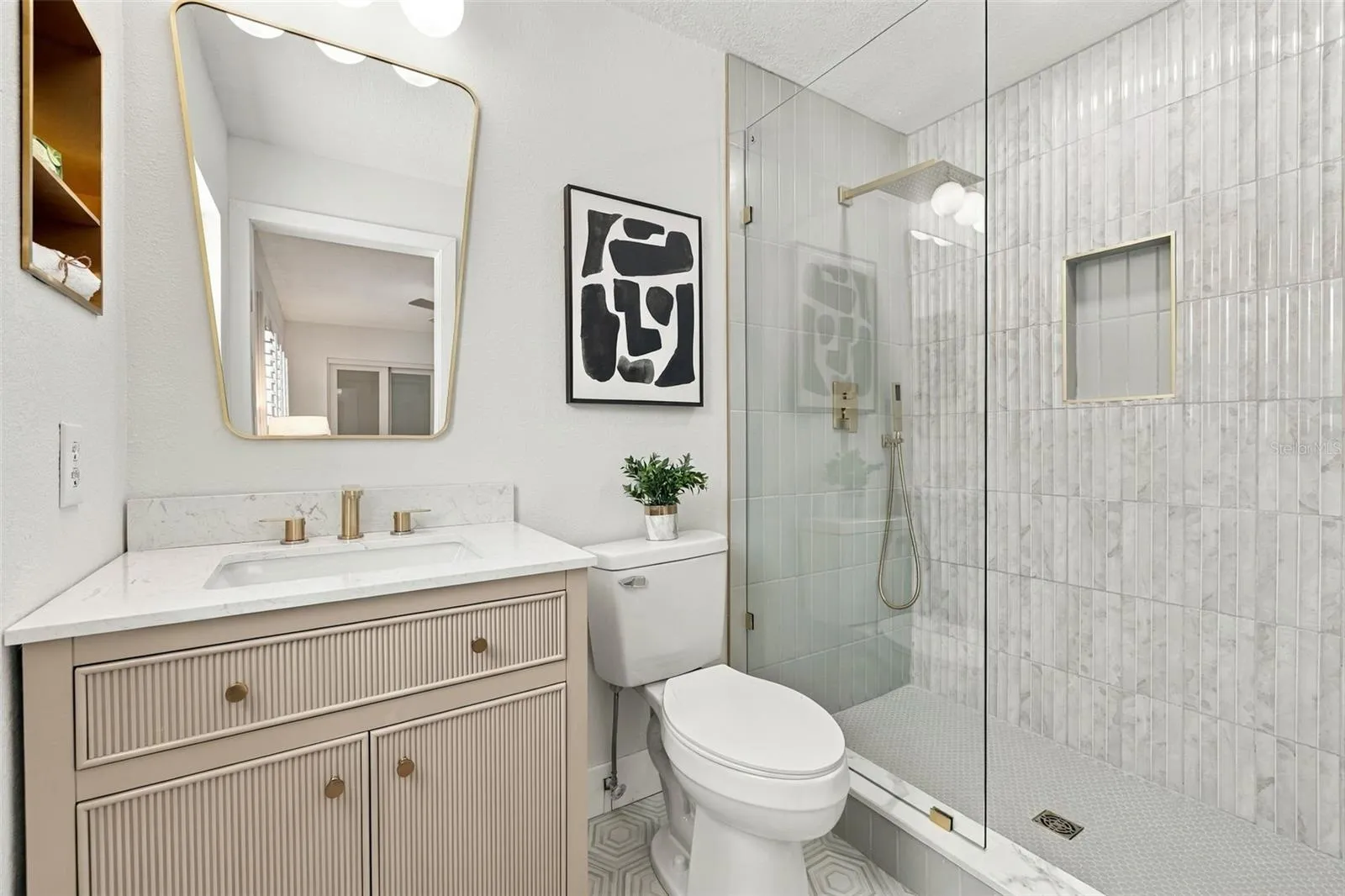 Primary bathroom with hexagon flooring, Quartz vanity, seamless glass shower with gleaming tile finish