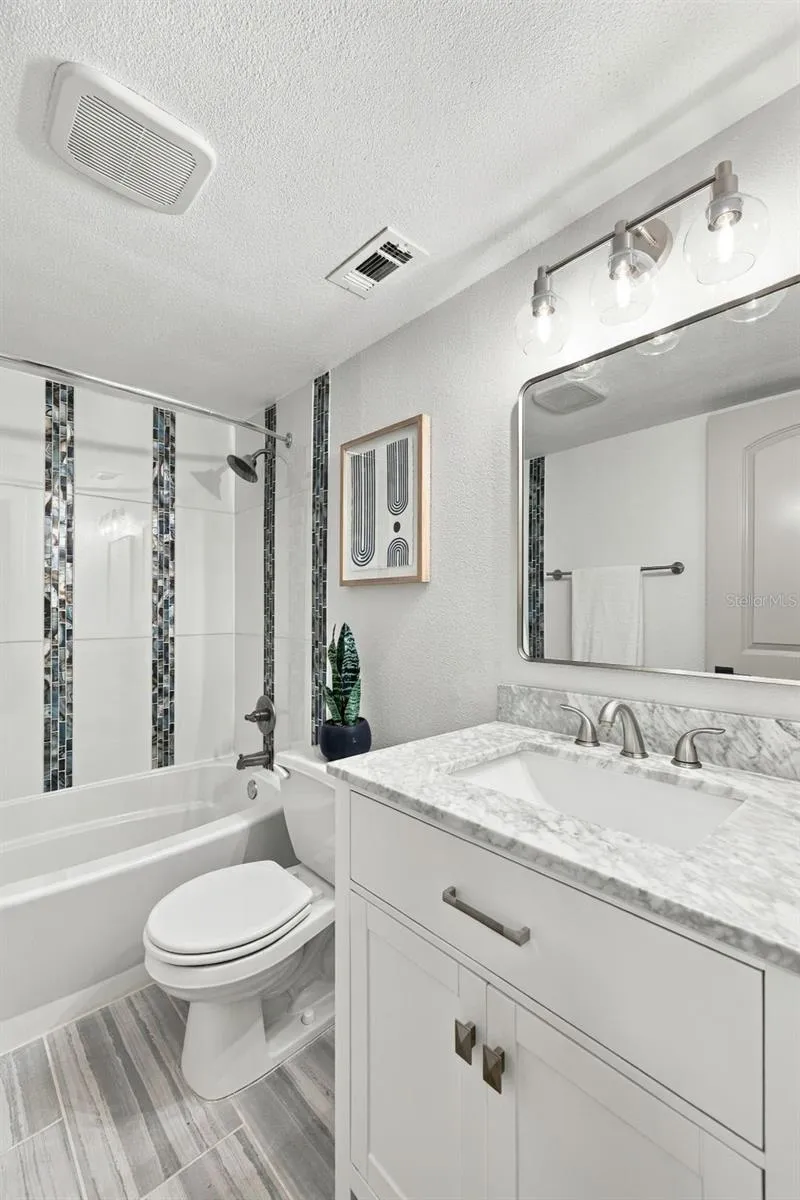 Hall bathroom with Marble vanity and updated shower/tub combo