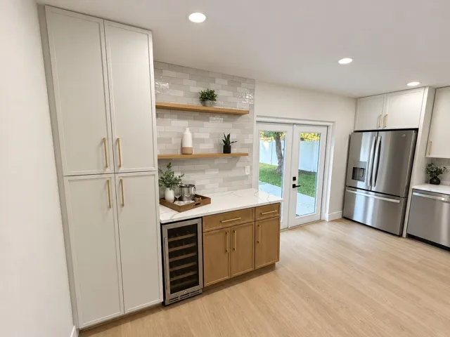 Cabinet pantry, beverage cooler, floating shelves and French doors out to pool
