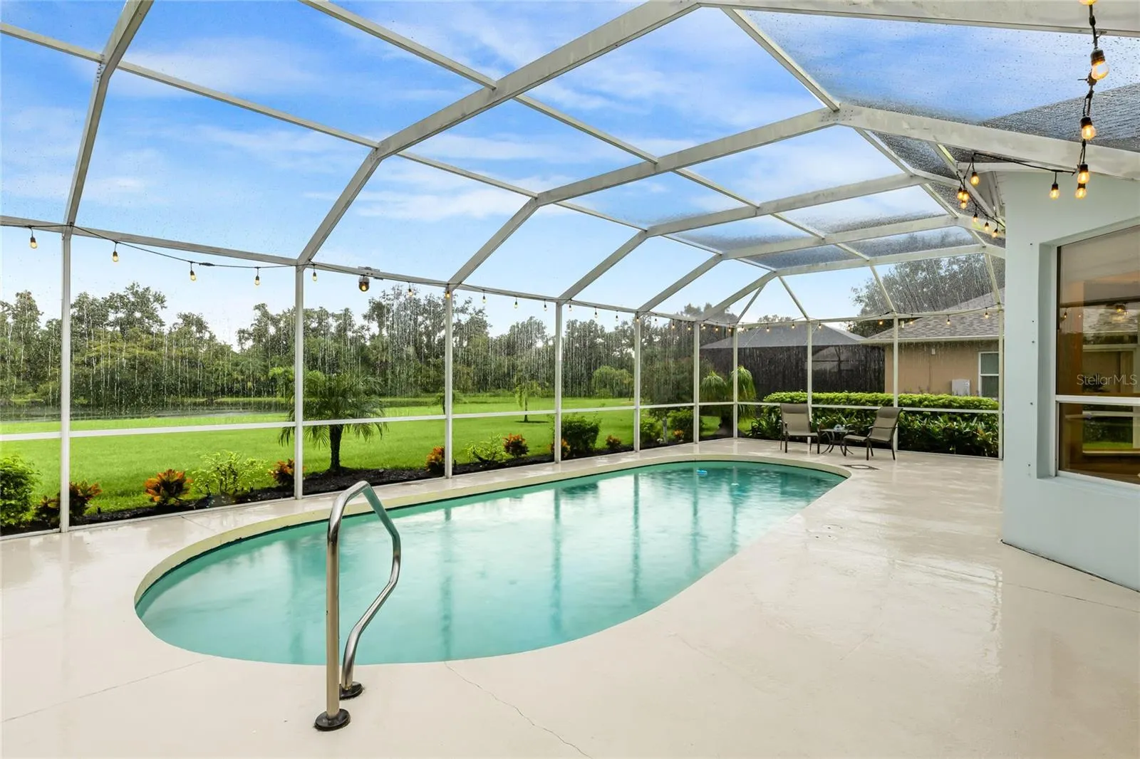 Private in-ground pool with a lake view, featuring a new pool pump, custom landscaping with hard-wired lighting.