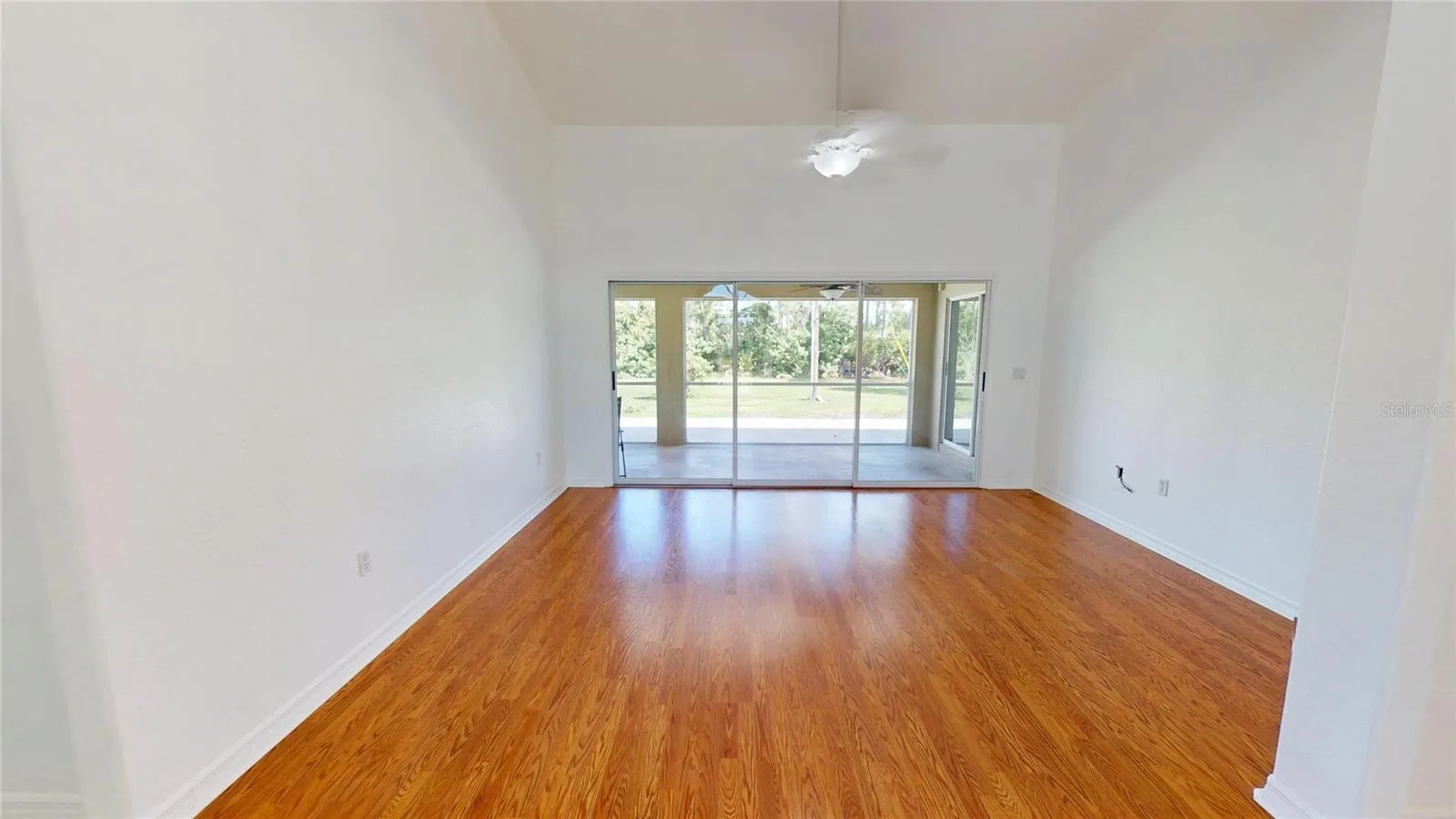 Living room has vaulted ceilings and gleaming laminate flooring.