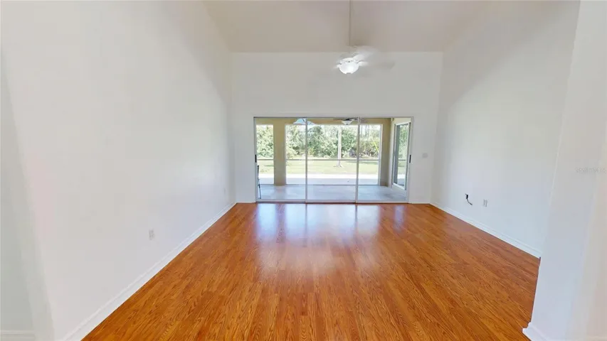Living room has vaulted ceilings and gleaming laminate flooring.