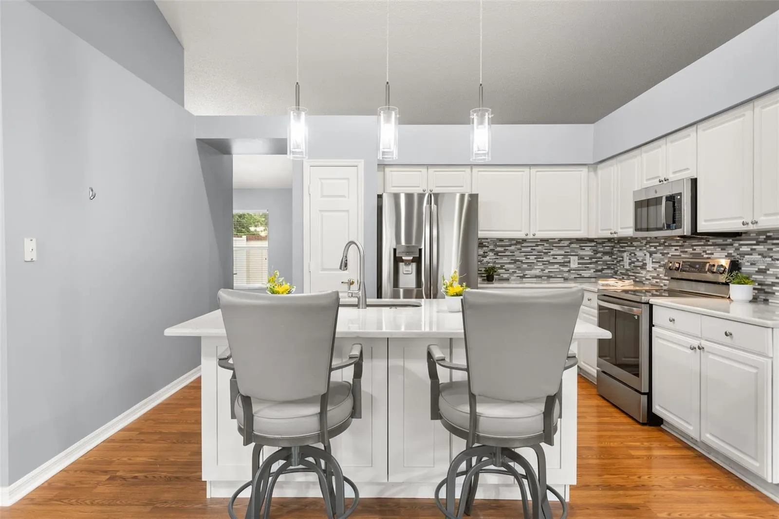 Large island with cabinets and updated pendant lighting