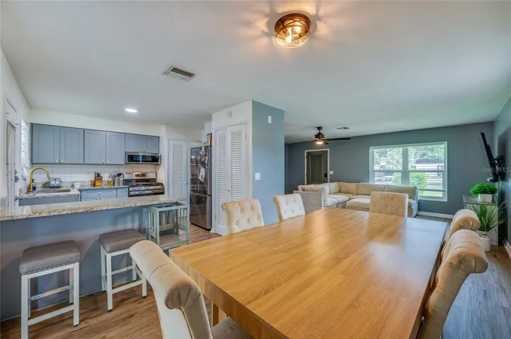 Open-concept floor plan offering seamless flow between the primary living areas, framed by LVP flooring and overhead lighting.