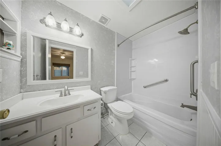 Primary en-suite, with wainscotting, comfort height toilet, and tub/shower combo with grab bars