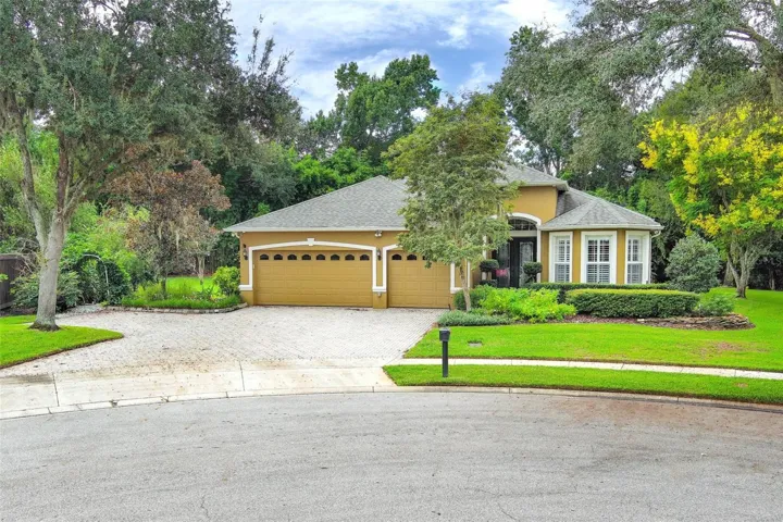 Front elevation with 3 car garage and additional pavered parking pad off to left