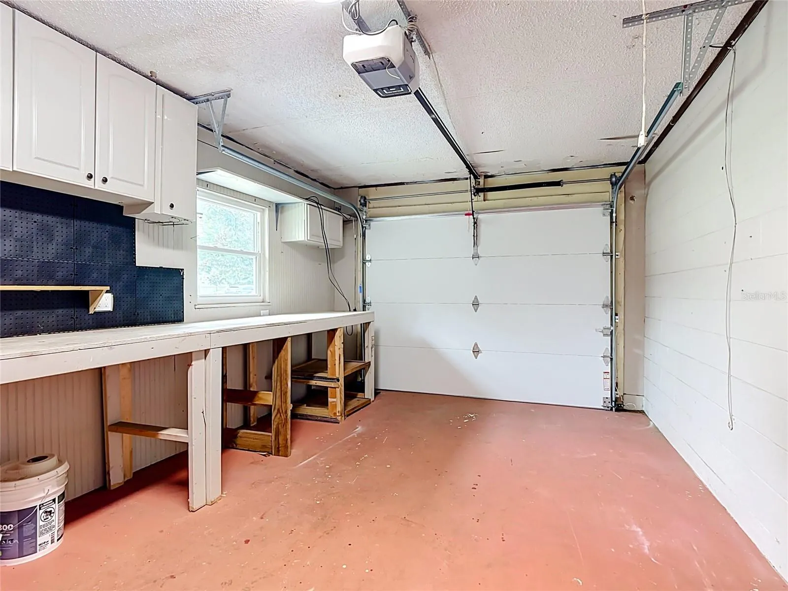 Garage with new insulatated door, custom workbench and tons of storage cabinets.
