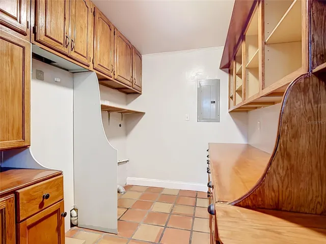 Pantry/storage room with custom cabinetry and laundry hookups.