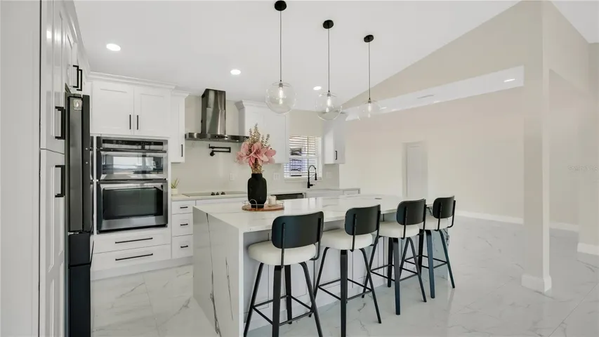 Kitchen with built-in oven and range hood