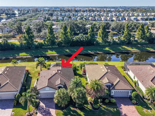 Aerial view of house facing south, pond, trees