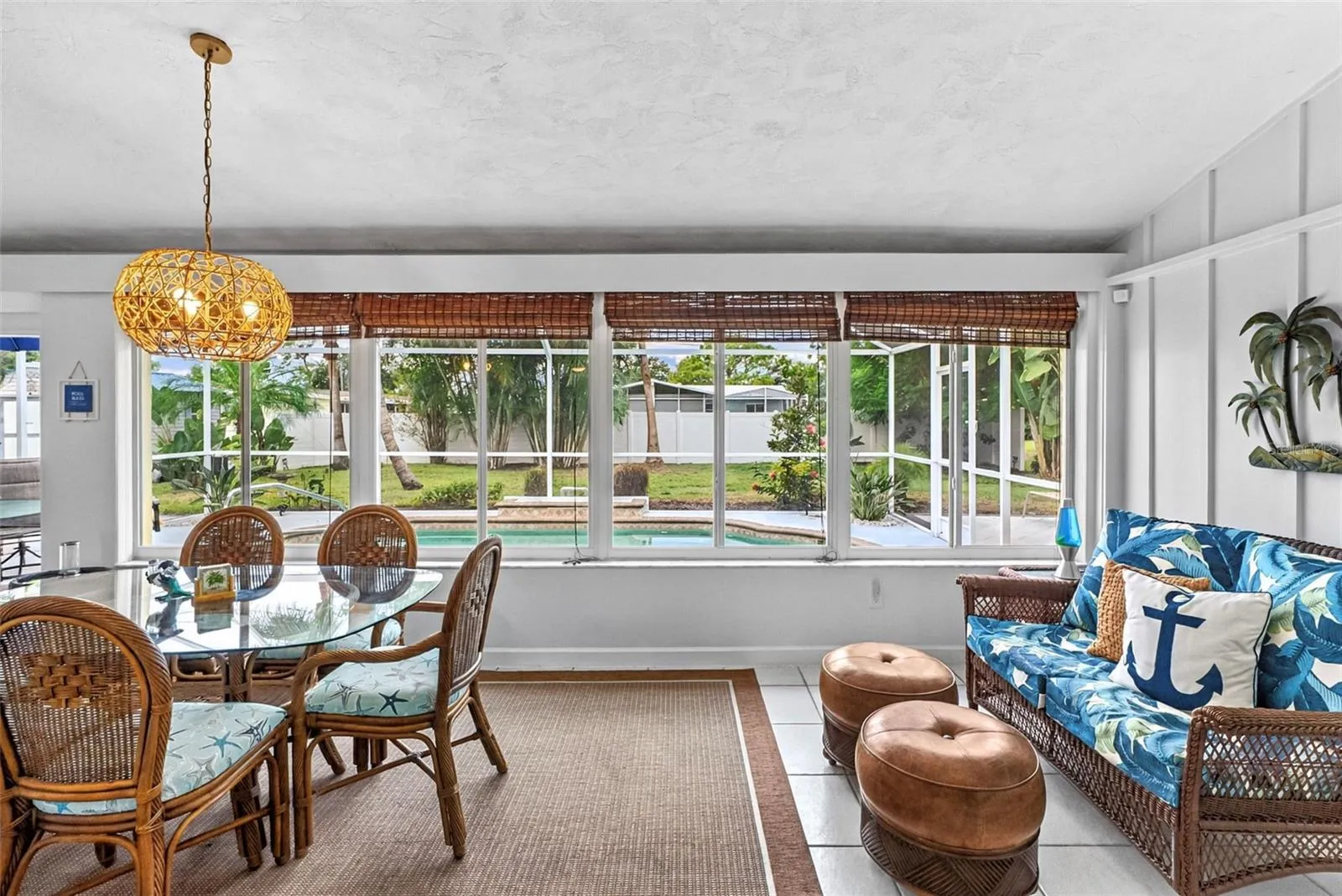 Florida room with dining and sitting areas overlooking the pool.