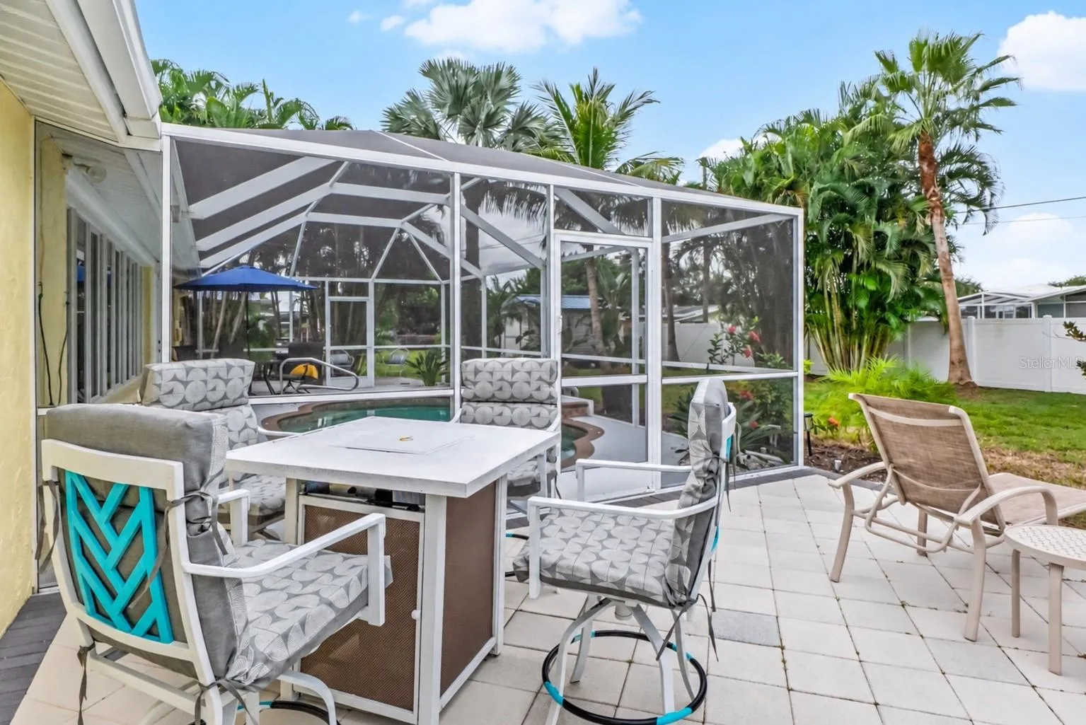 Outdoor dining patio beyond the screened pool enclosure.