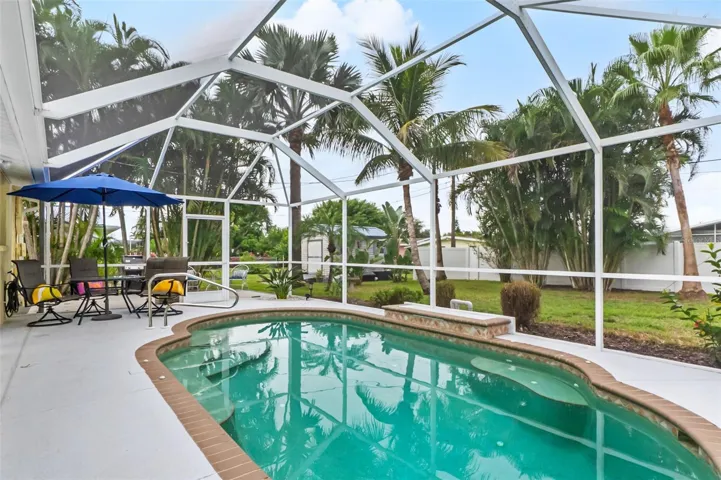 Alternate view of the pool with poolside seating and outdoor dining area.