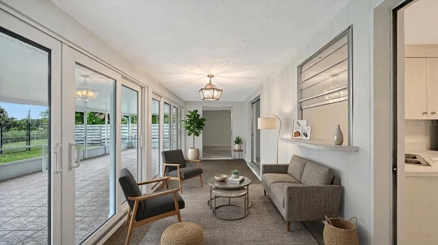 Staged Florida Room with Newer Impact Resistant Sliding Glass Doors all the way across!