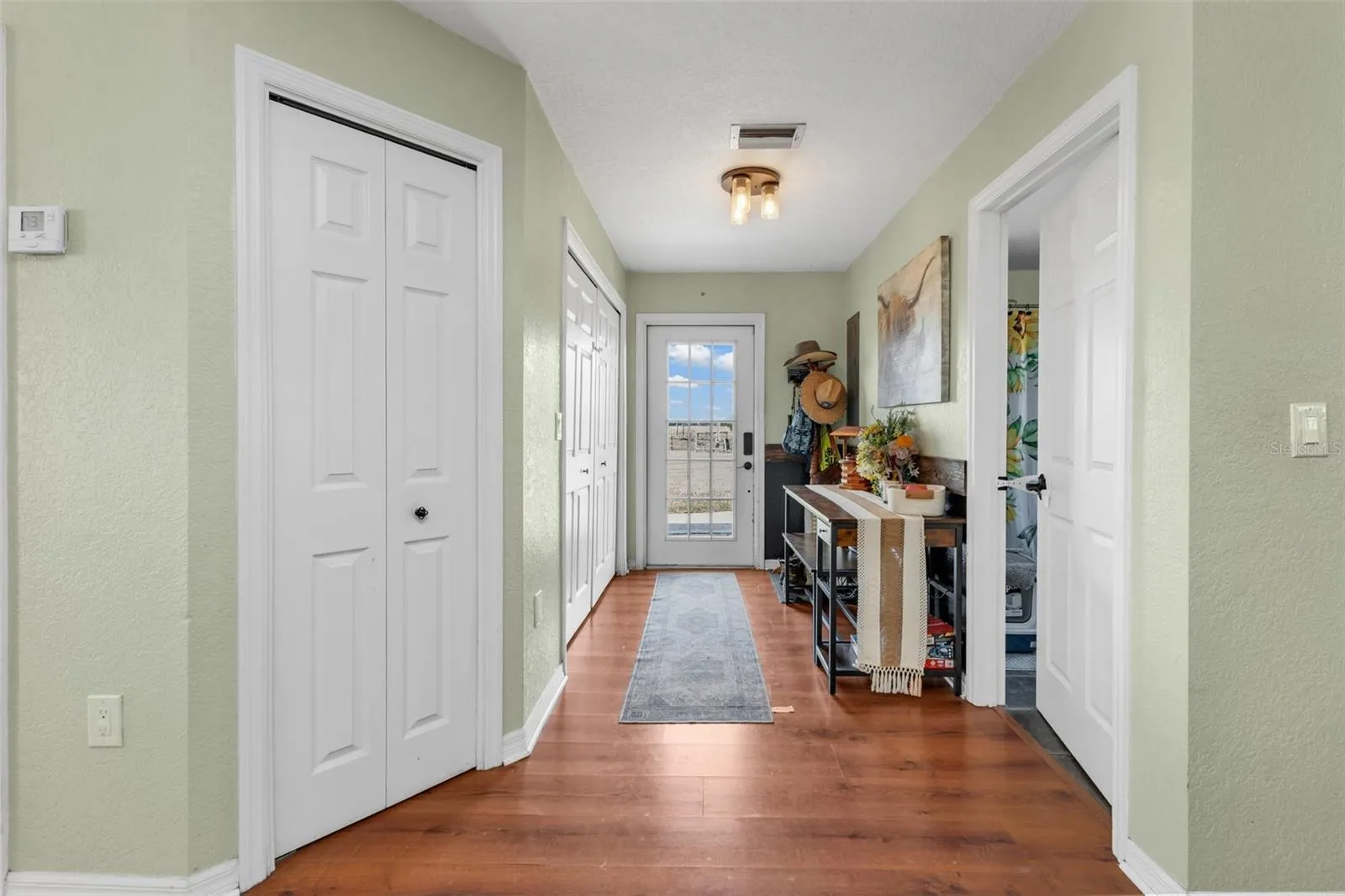 Hall to side entry. Laundry closet on left and guest bathroom on right.