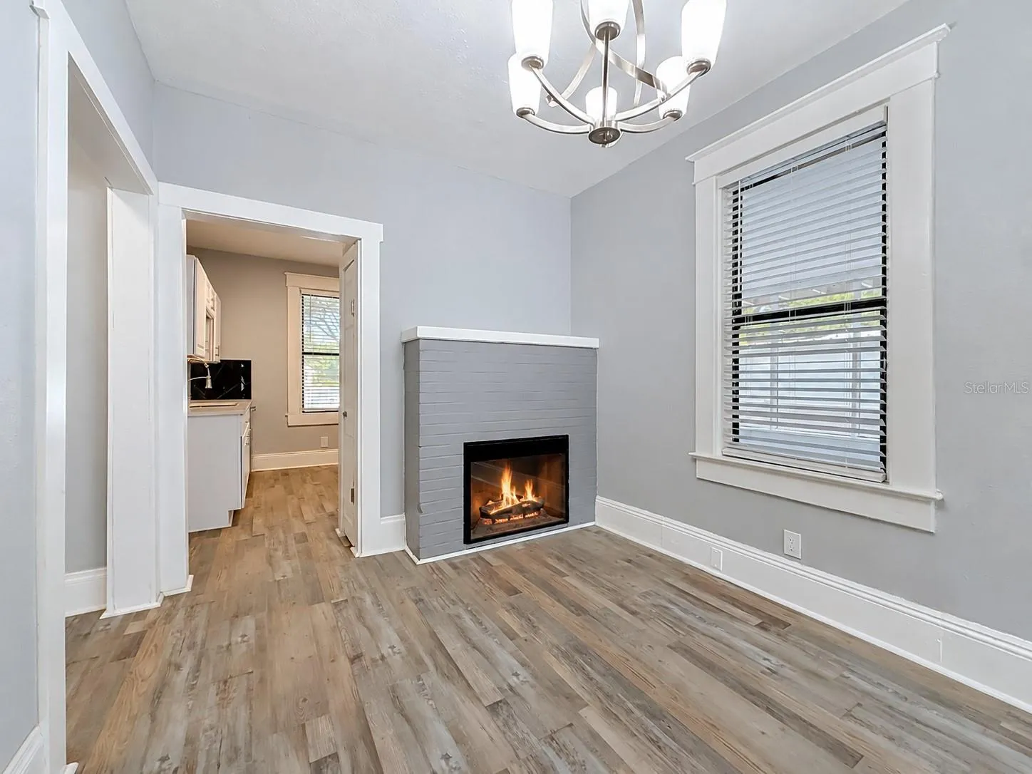 Dining room area with electric fireplace and view into kitchen