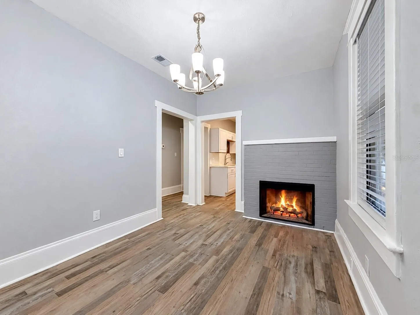 Dining room area with electric fireplace and view into kitchen