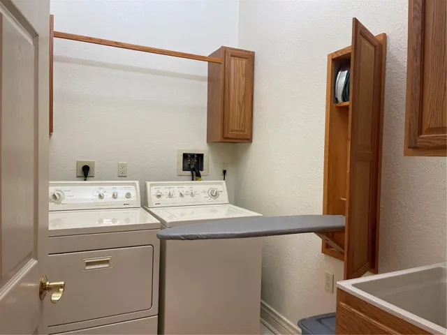 Washer, dryer and stand up sink in laundry room on second floor