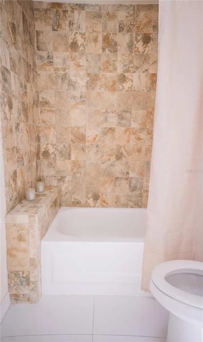 Beautifully tiled secondary bathroom featuring modern finishes and updated fixtures.
