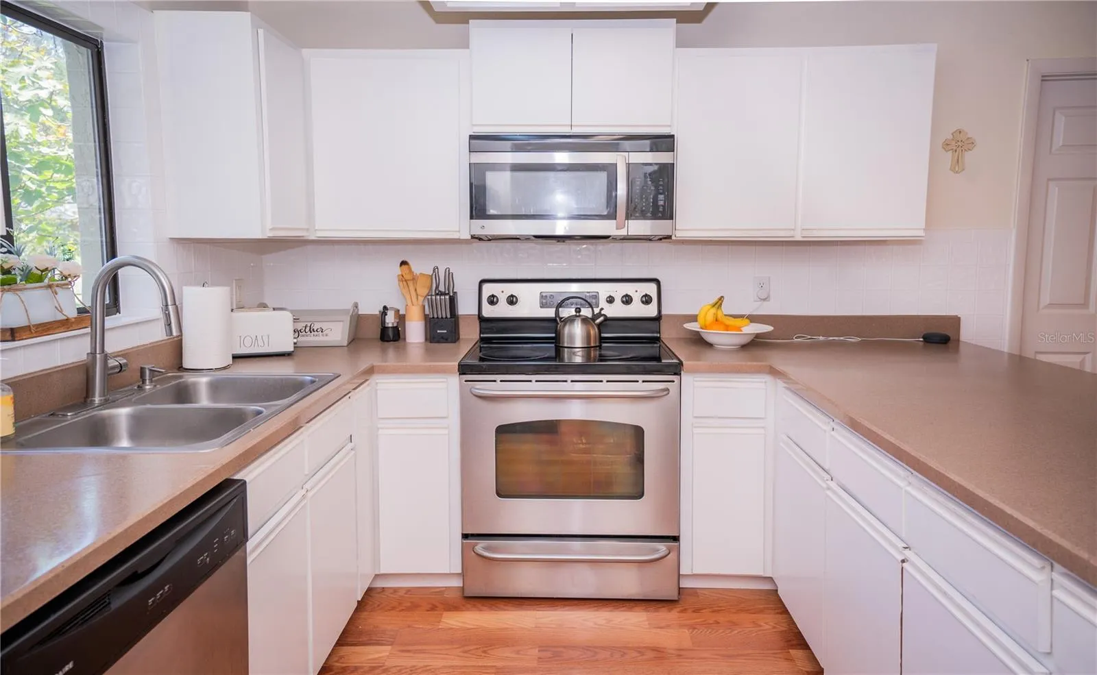 Modern kitchen featuring stainless steel appliances, including a range and built-in microwave.