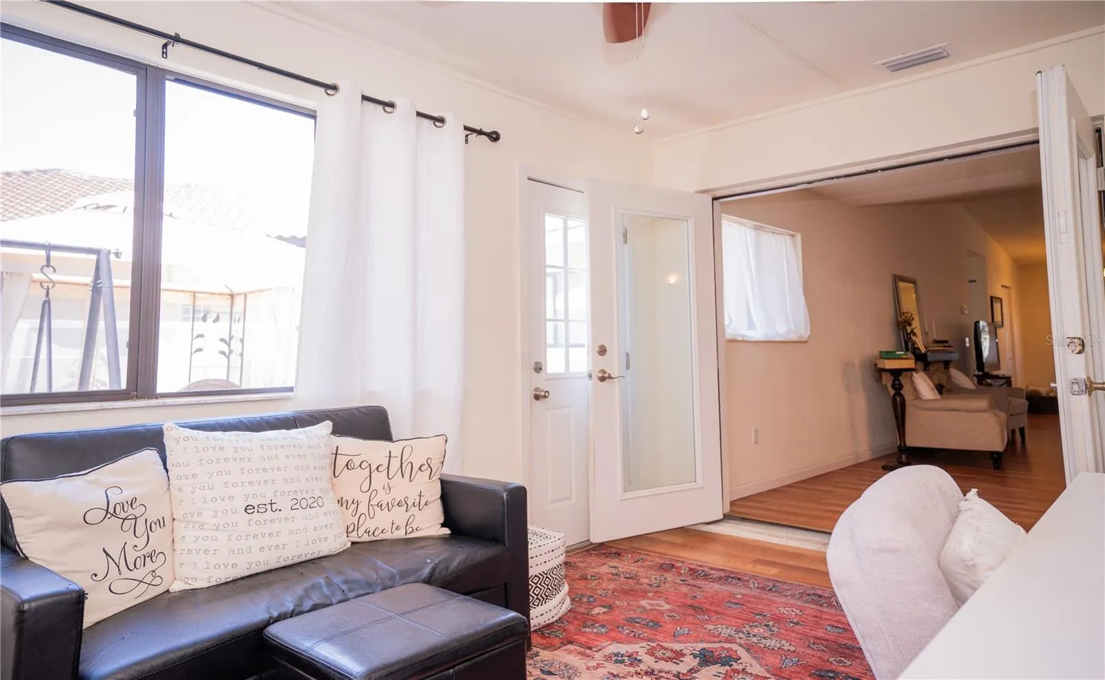 The view from the office space looking through the French doors into the living room, featuring a seamless flow to the outdoor patio—perfect for entertaining.