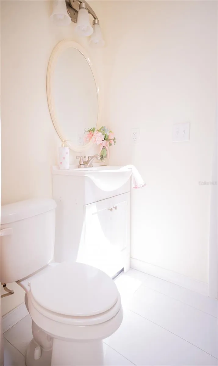 Modern vanity featuring sleek, elegant granite countertop with chrome hardware, and spacious cabinetry for optimal storage in the second bathroom.