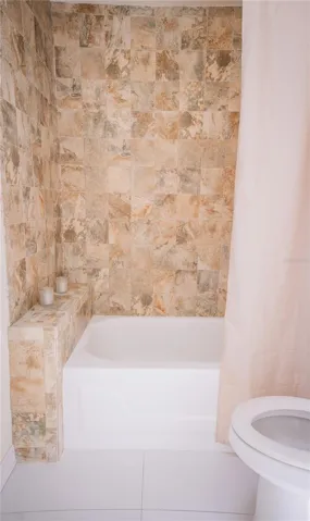 Beautifully tiled secondary bathroom featuring modern finishes and updated fixtures.