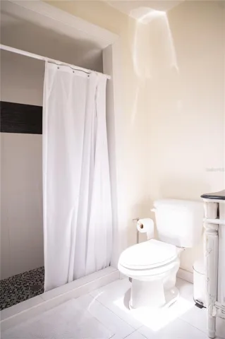 Ensuite primary bathroom featuring a spacious walk-in shower and private water closet.