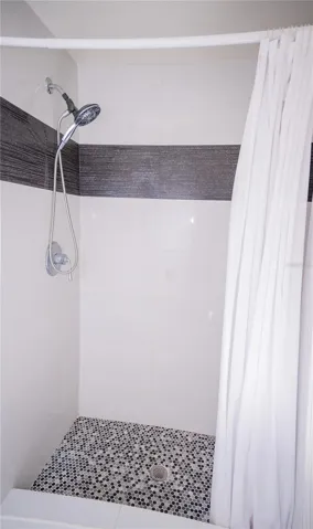 This custom shower features high-end designer tile work, premium fixtures, and luxury tile flooring.