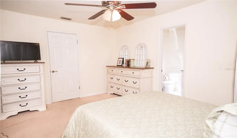 Primary bedroom featuring an ensuite bathroom with abundant natural light.