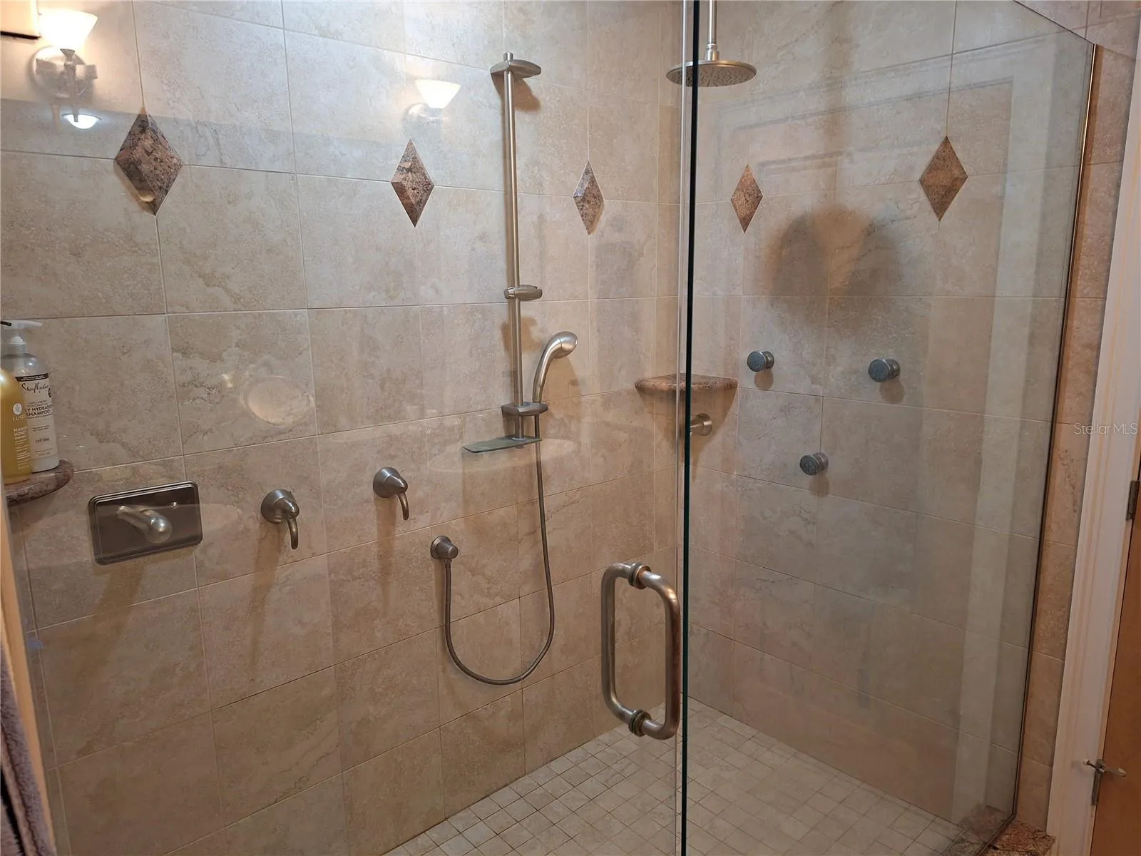 Primary  Bedroom with huge walk-in shower with multiple shower heads.