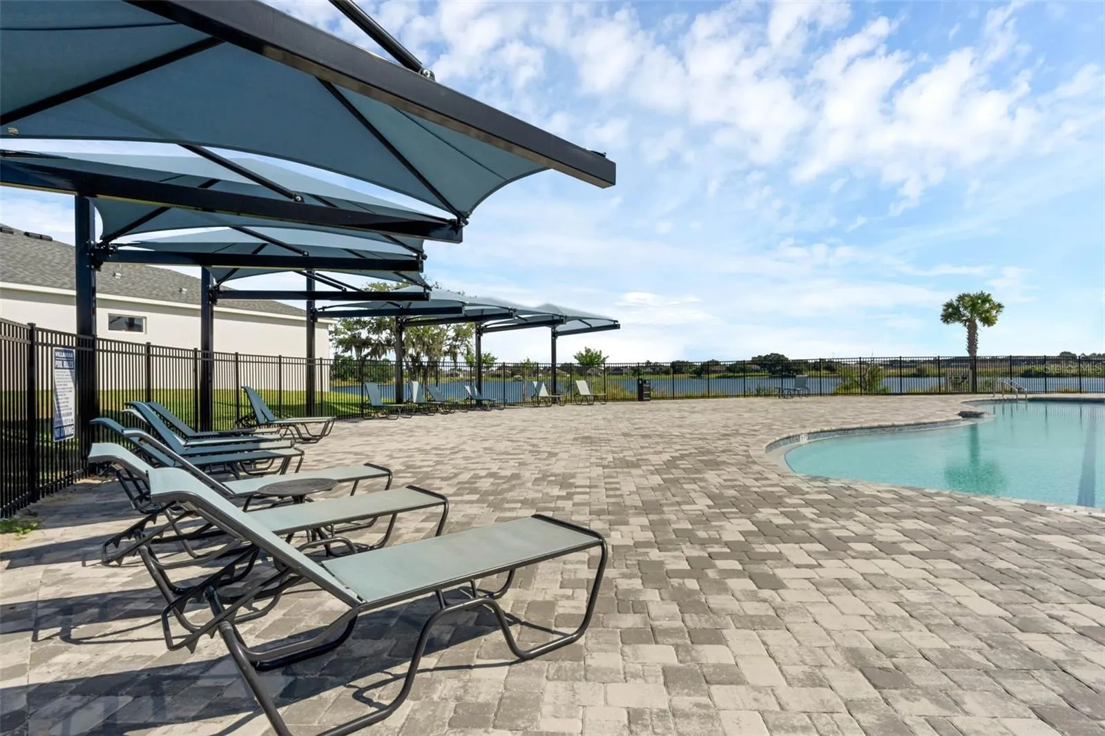 Pavers are featured in the community pool lounging area
