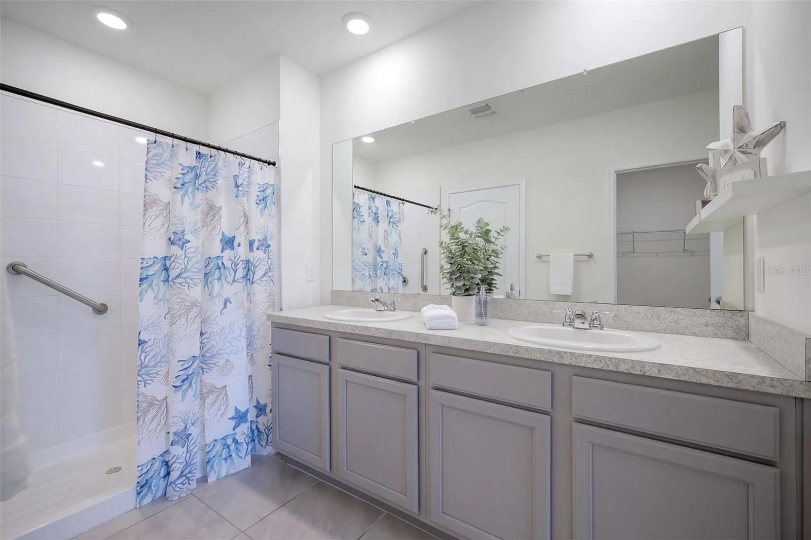 The Primary En-suite bathroom features a comfort-height vanity with dual sinks &amp; a linen closet