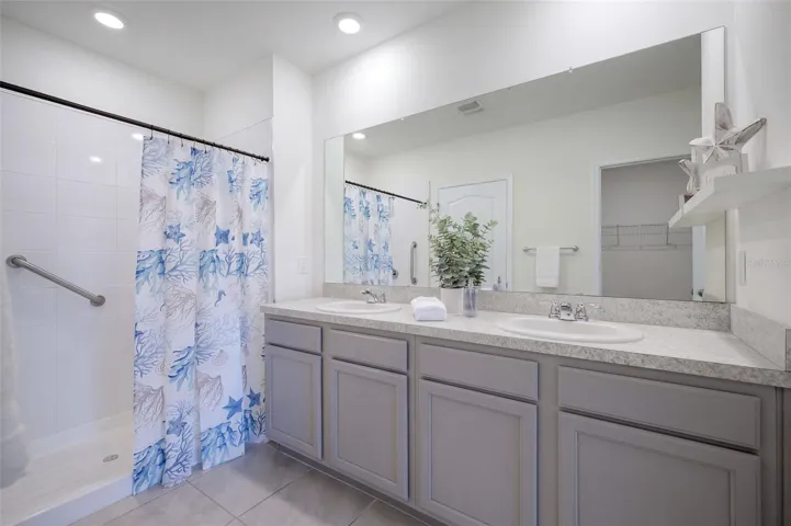 The Primary En-suite bathroom features a comfort-height vanity with dual sinks &amp; a linen closet