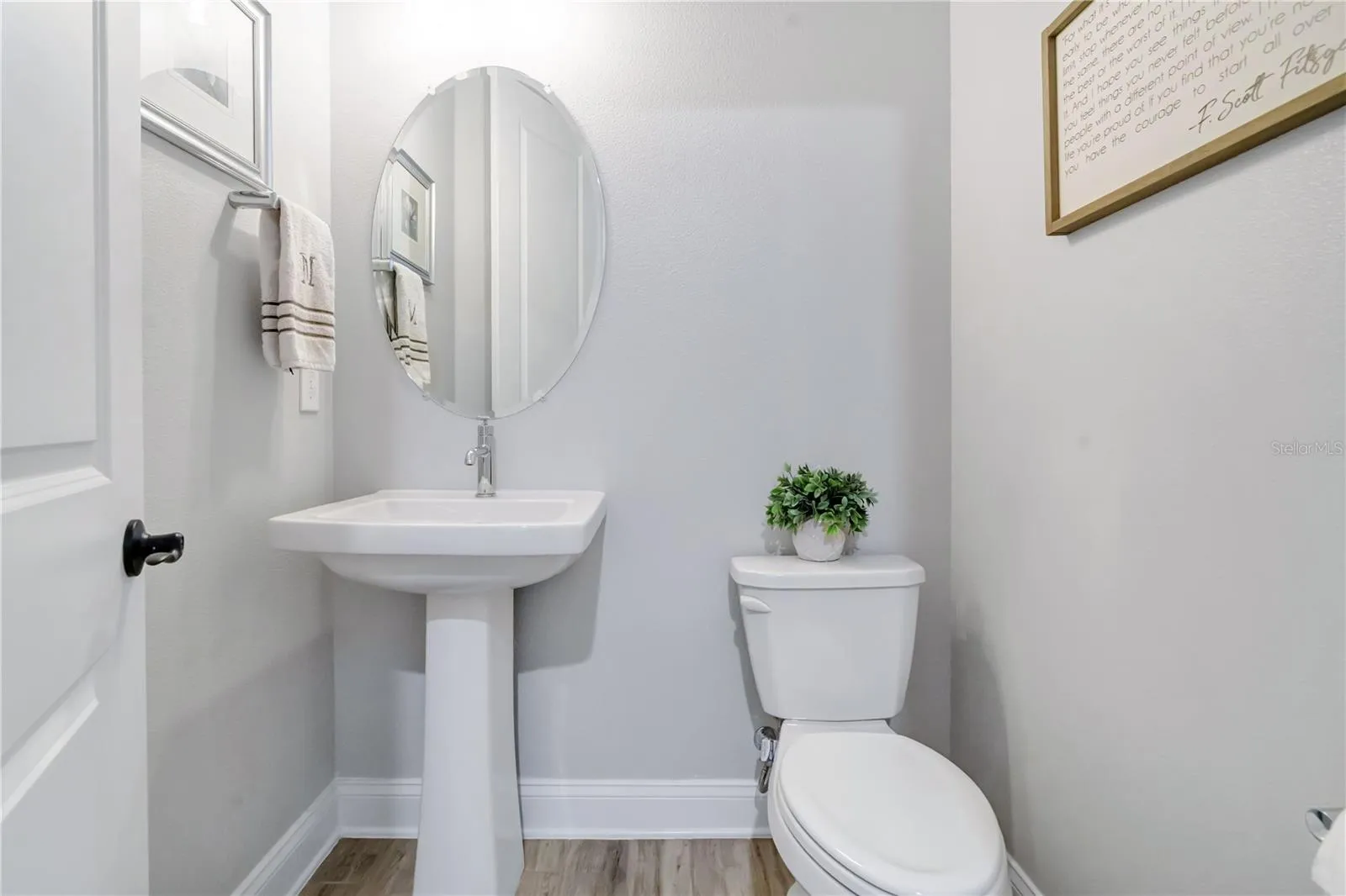 Convenient half bath with pedestal sink and modern finishes.