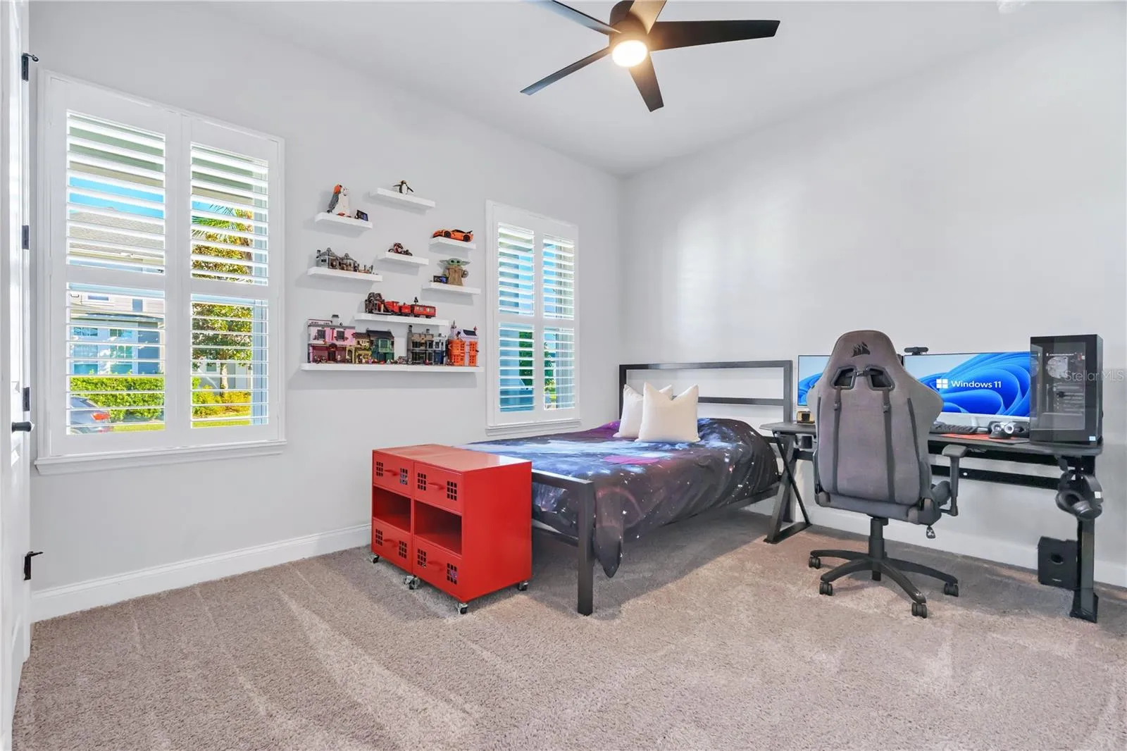 Secondary bedroom with room for a desk, ceiling fan, and plenty of natural light.