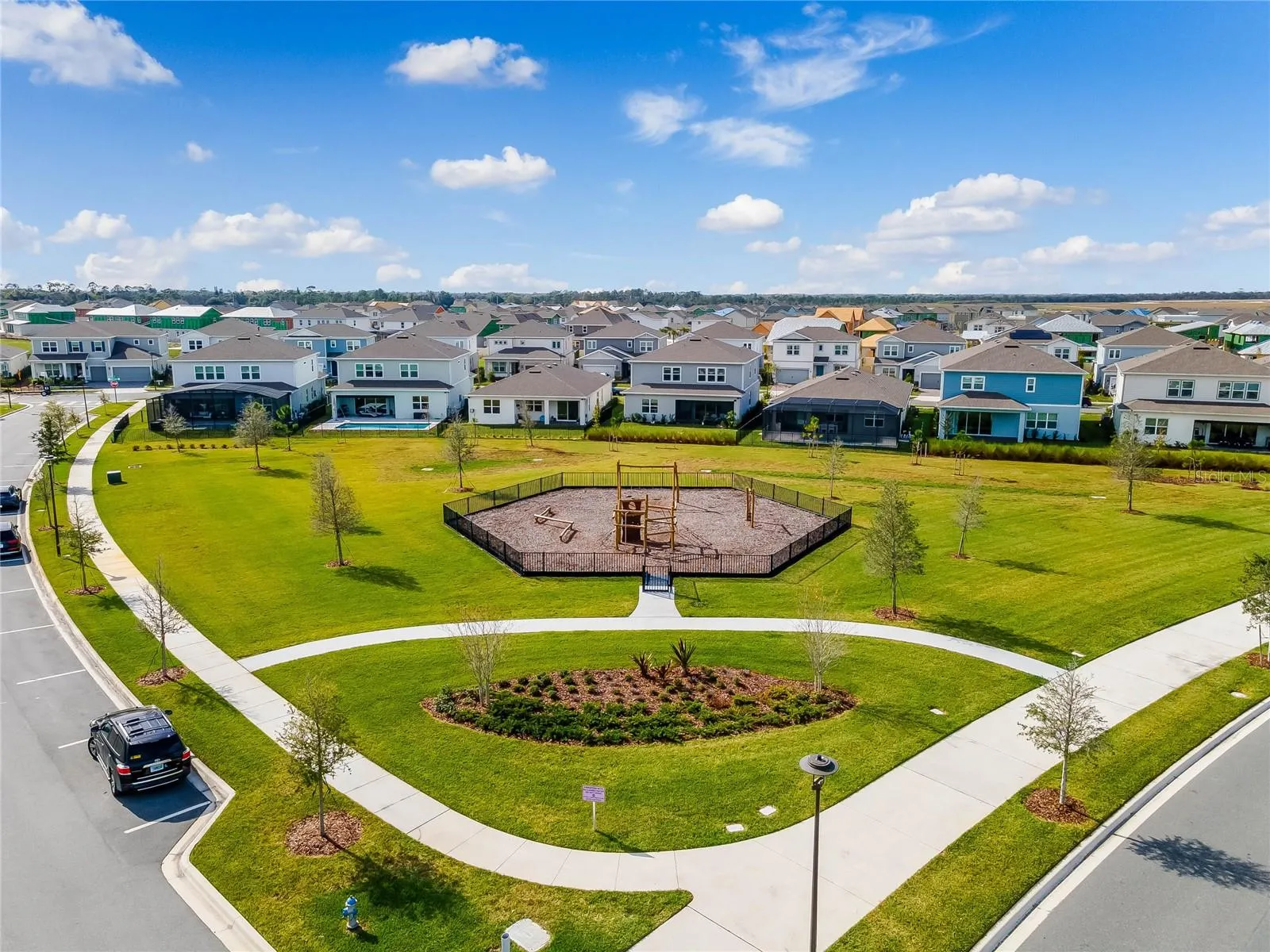 Landscaped neighborhood park with winding walking paths in Laureate Park.