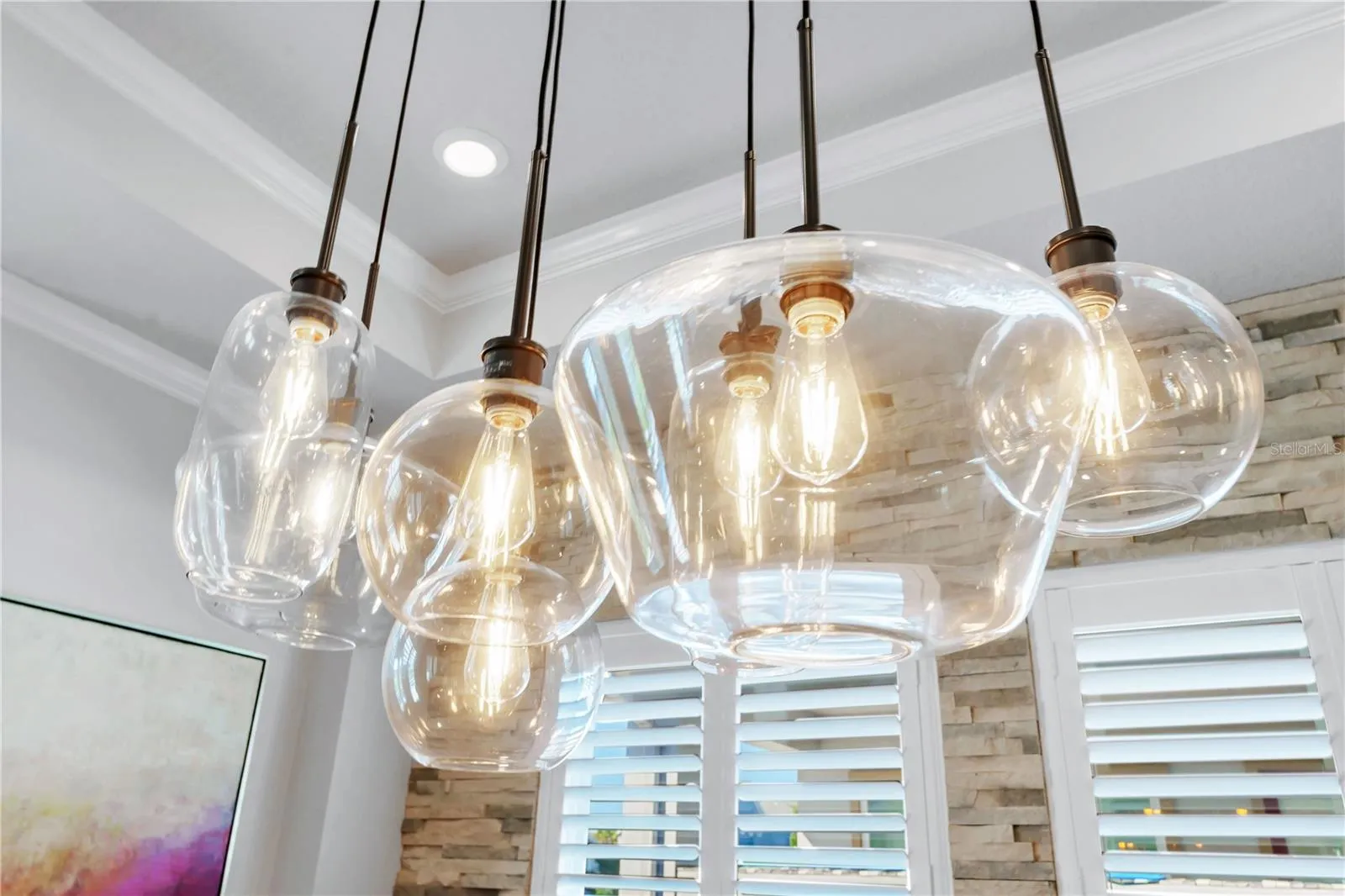 Designer glass pendant lights over the dining table add warmth and style.