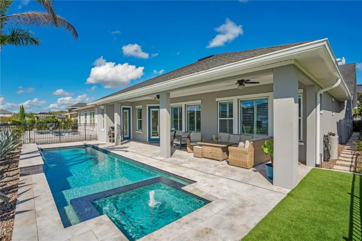 Rear exterior with private heated salt water pool and covered extended lanai. Florida outdoor living in Lake Nona, Orlando.