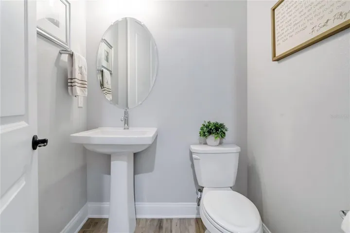 Convenient half bath with pedestal sink and modern finishes.