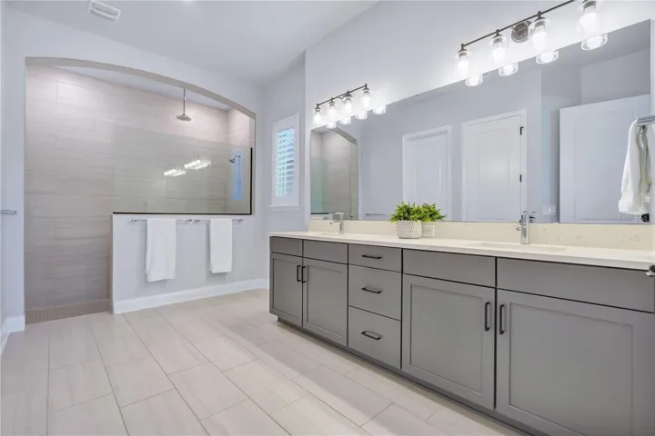 Primary bath with a Carrara Marmi quartz double vanity, extra drawer storage, and a large walk in shower.