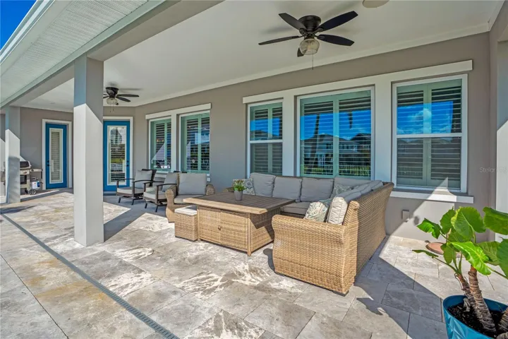 Covered lanai lounge with ceiling fan, perfect for relaxing year round in Central Florida.