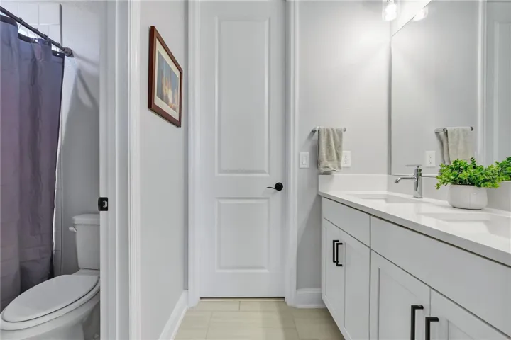 Full bath with shower and tub combination and quartz vanity.
