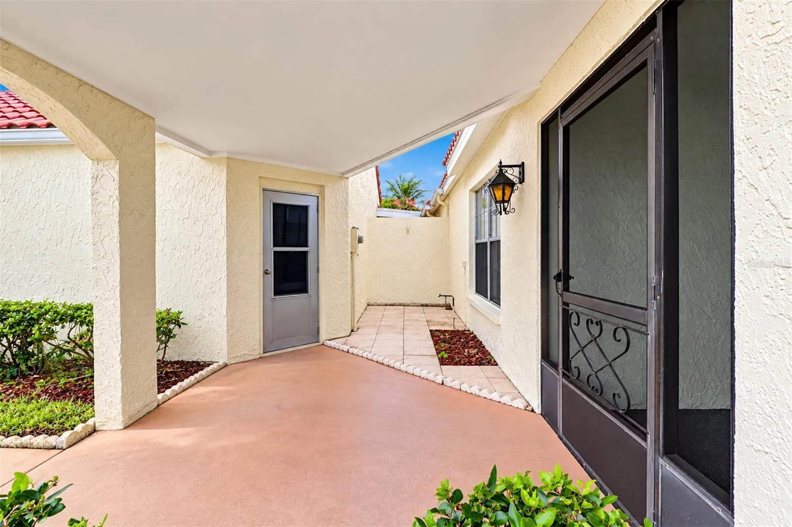 View of the pedestrian door from the garage and the extra patio area in front of the garage wall