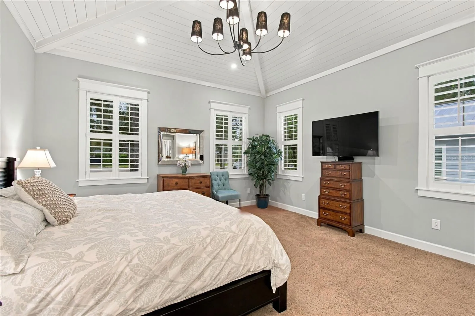 First flood Primary Bedroom with beautiful valuted ceiling with custom wood details..
