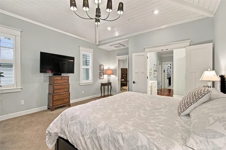 First flood Primary Bedroom with beautiful valuted ceiling with custom wood details..