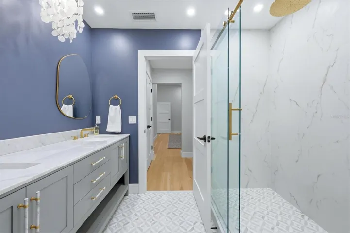 Primary Bathroom with Double Sinks and Carerra Marble vanity top and glass enclosure shower